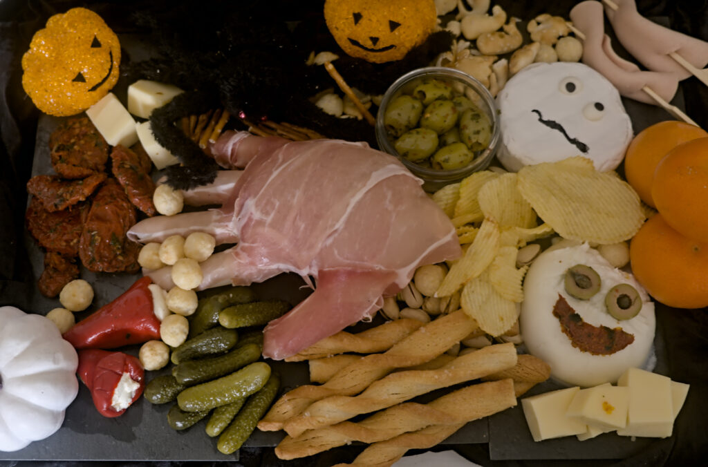 auf einem schwarzen Untergrund befindet sich verschiedene Snacks. Ein Halloween -Snackbread Halloween