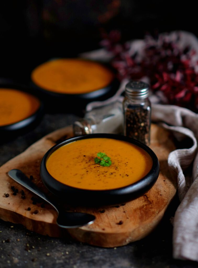 Eine Schüssel Gemüsecremesuppe mit Kräutern serviert