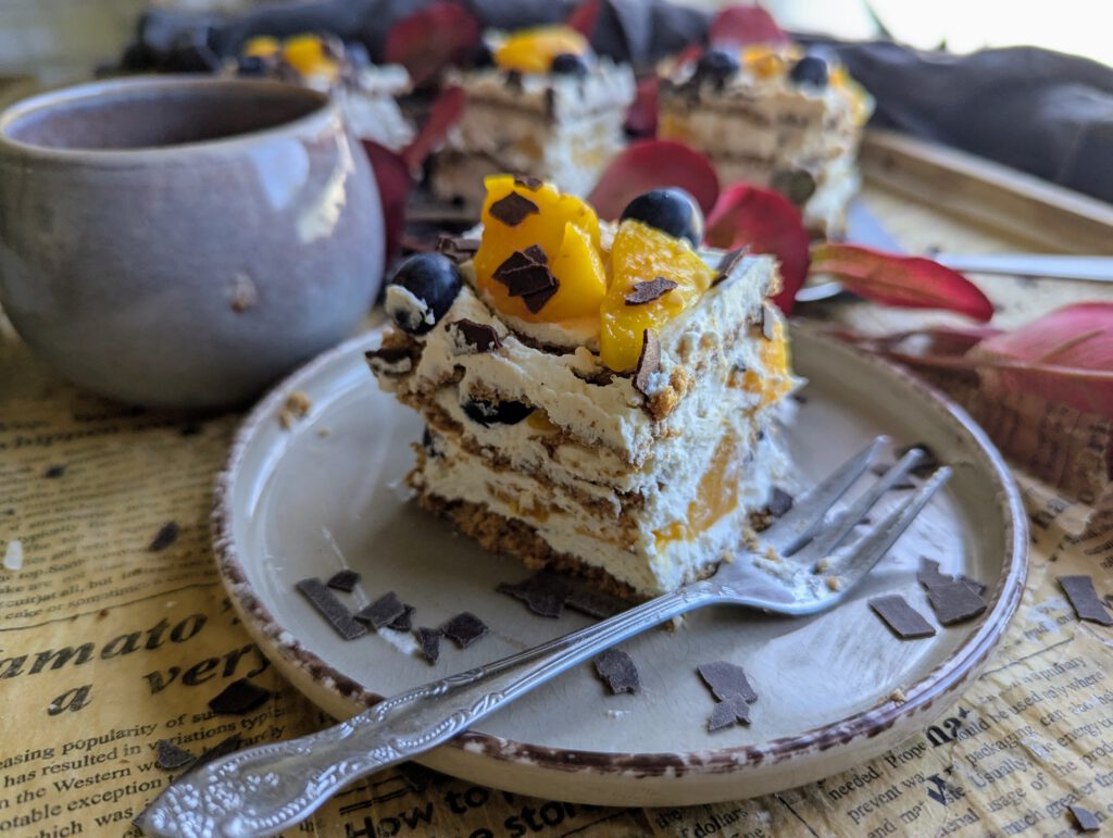 Butterkeksschnitte auf einem grauen Teller, im Hintergrund sind noch mehr Stückchen zu erkennen