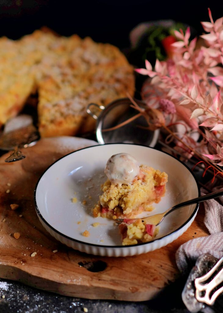 ein Stück Rhabarber-Streuselkuchen mit Vanilleeis