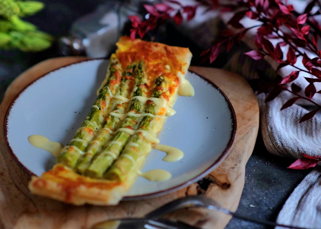 ein Stück Spargeltarte mit Sauce Hollandaise servierfertig angerichtet