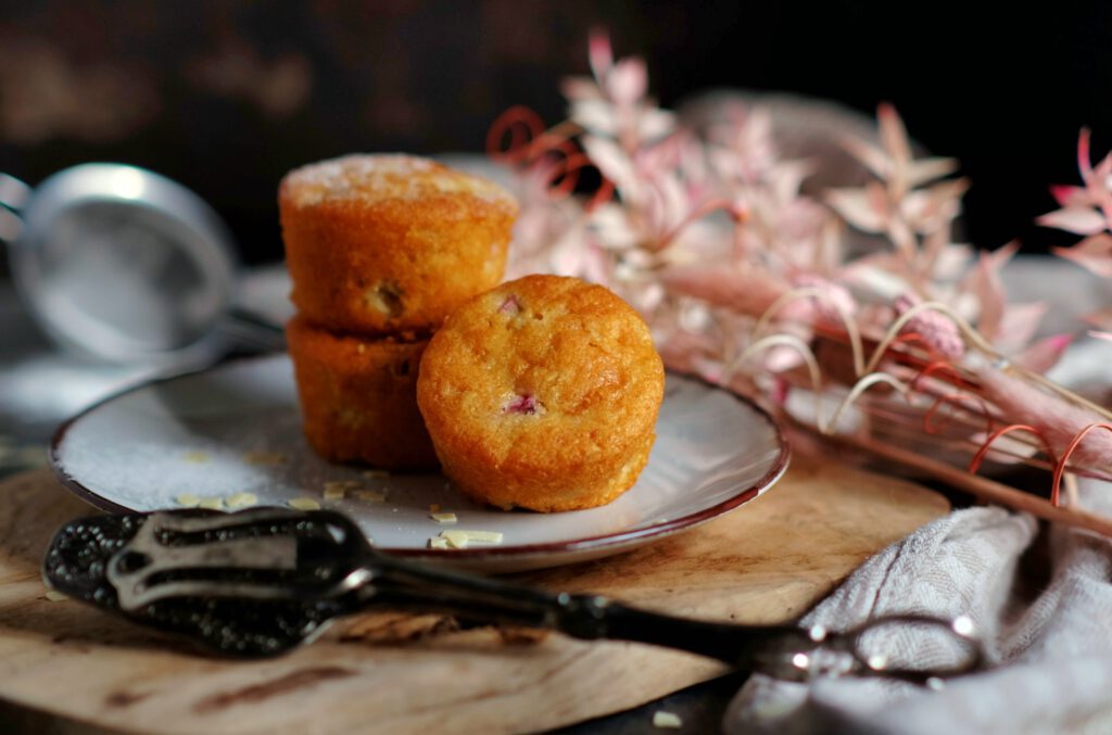 Rhabarber-Muffins mit Joghurt & weißer Schokolade, mit Puderzucker serviert