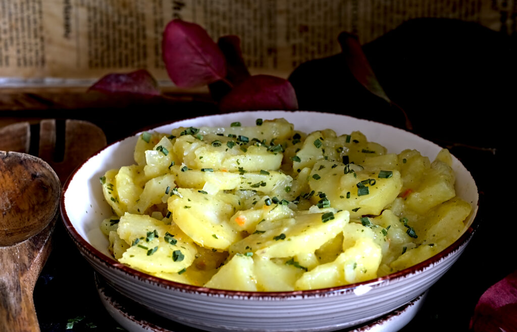 auf dem Bild siehst du eine Schüssel in der sich badischer Kartoffelsalat befindet, darüber wurde Schnittlauch gestreut