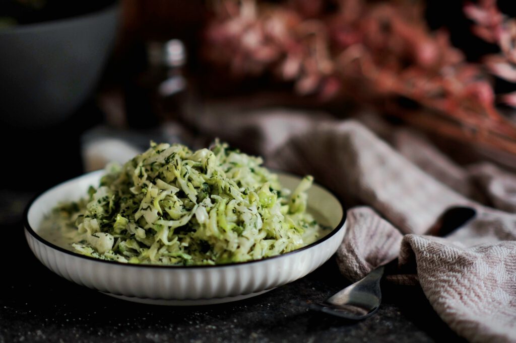 Ein Teller mit einer Portion Spitzkohl-Gurken-Salat, serviert als Beilage zum Grillen