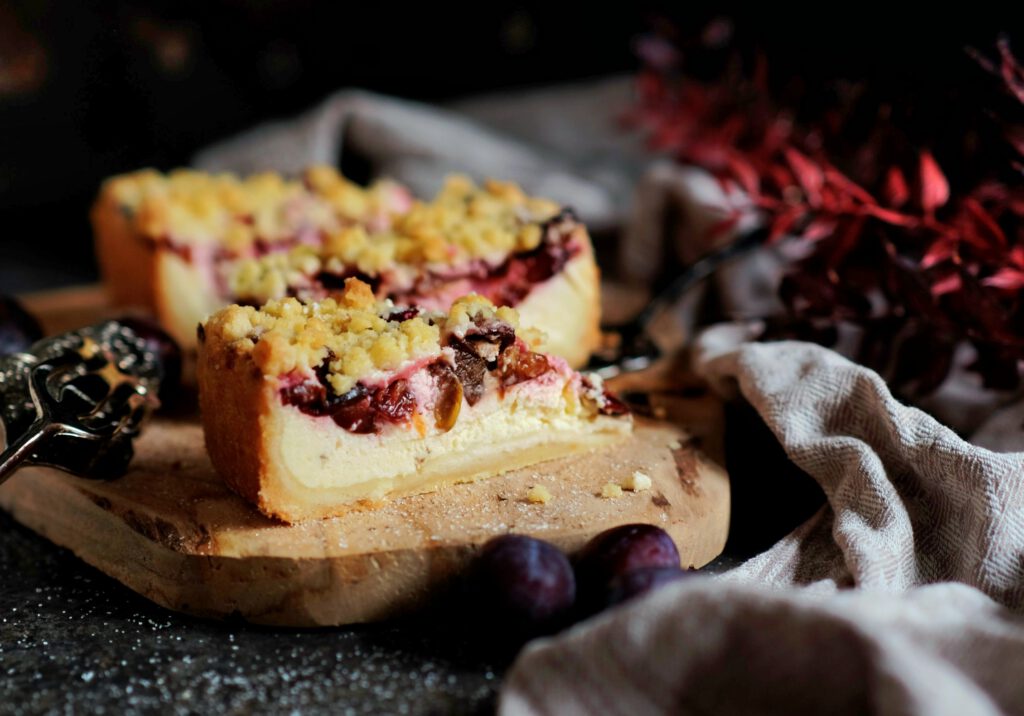 Zwetschgen-Käsekuchen mit Streuseln auf einem Holzbrett serviert