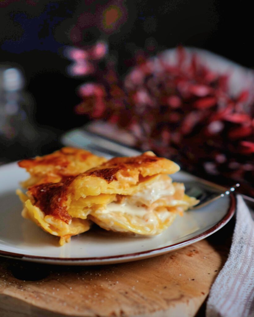 Portion cremiges Kartoffelgratin auf einem Teller als perfekte Beilage