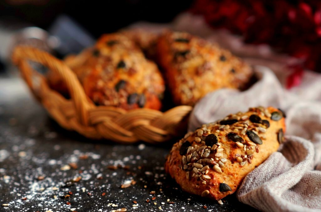 Goldbraun gebackene Proteinbrötchen mit Quark auf einem Holzbrett angerichtet