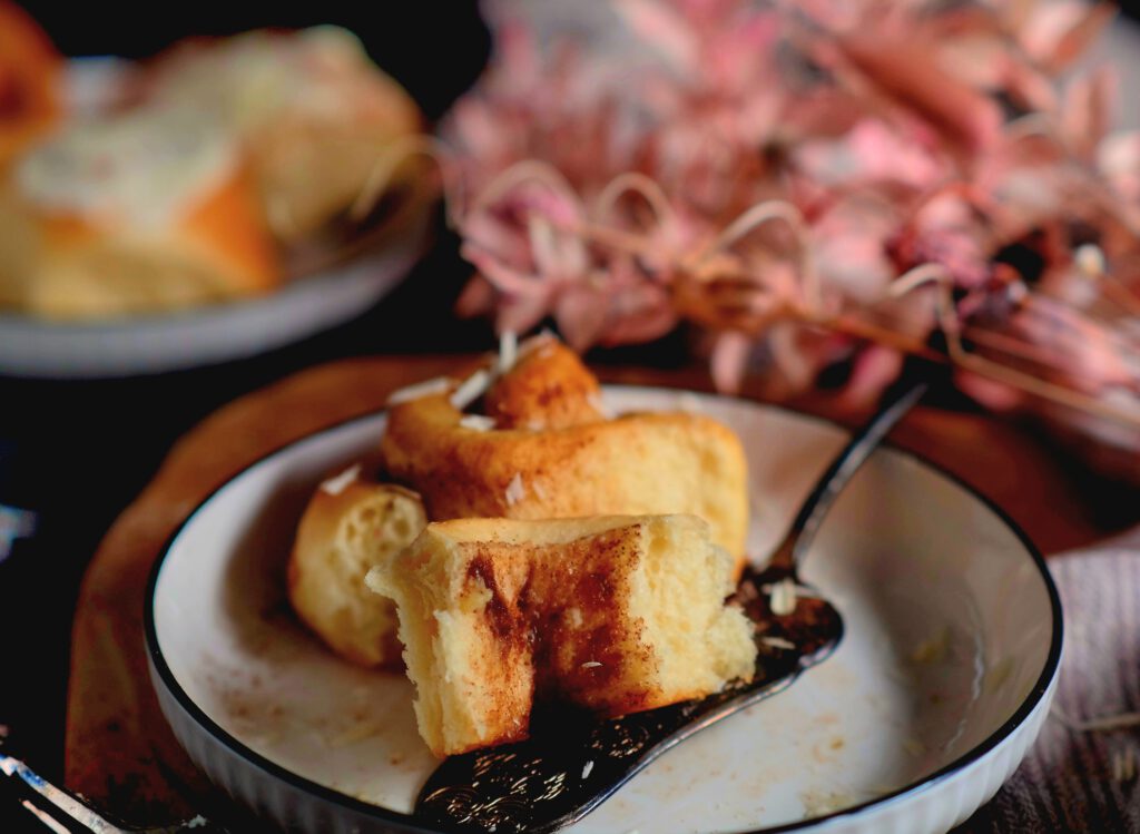Nahaufnahme einer aufgerissenen Zimtschnecke, die die weiche, fluffige Textur innen zeigt