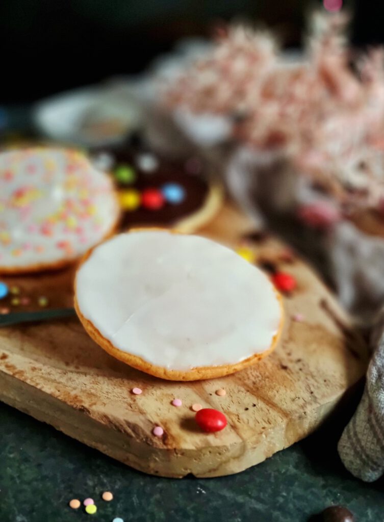 Amerikaner Gebäck: klassisch mit Zuckerguss, mit Schokogesicht und bunten Schokolinsengesicht oder mit buntem Zuckerstreusel-Dekor für eine Faschingsparty