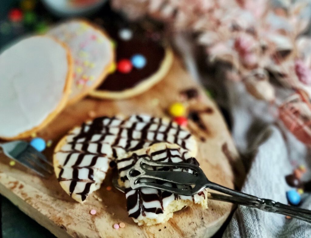 Amerikaner mit dunkler Kuvertüre und weißem Zuckerguss im Schwarz-Weiß-Look