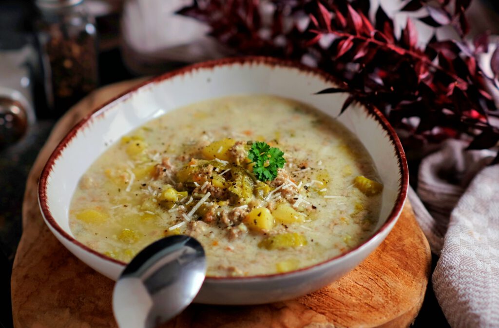 Dampfender Teller mit deftiger Käse-Lauch-Suppe, dazu frisches Baguette