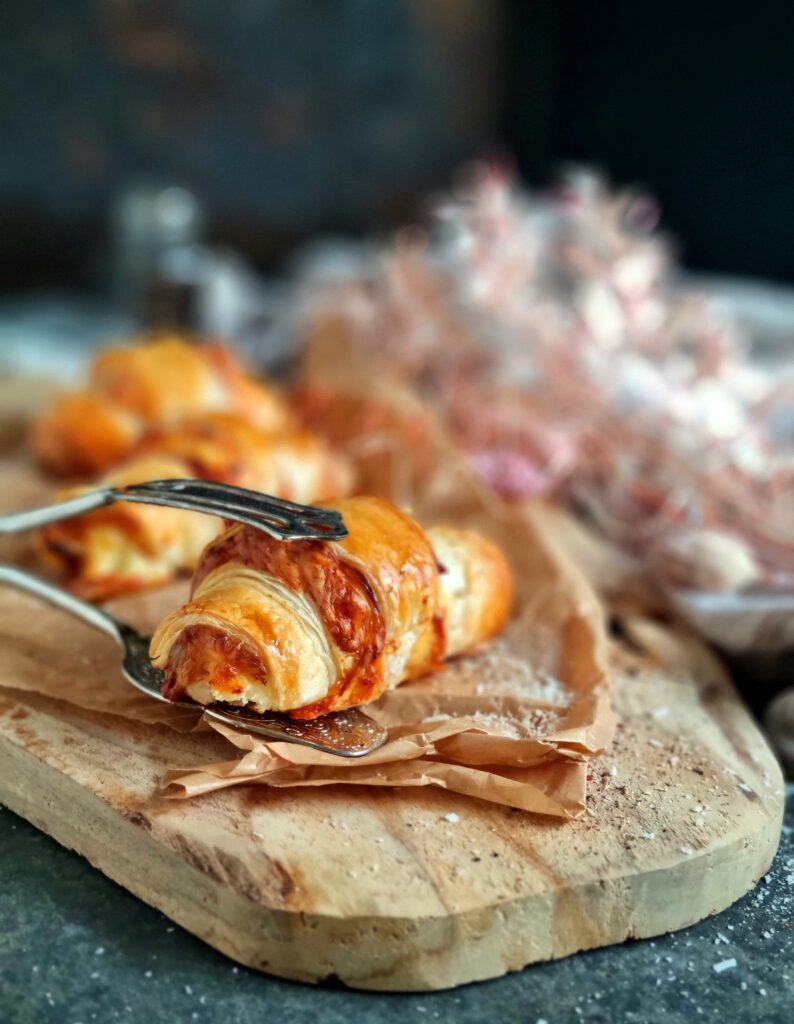 Goldgelber, verlaufender Käse, der an der Seite eines frischen Croissants herausquillt