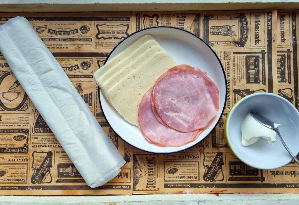 Zutaten für Käse-Schinken-Croissants: Käse, Kochschinken, Frischkäse, Blätterteig, Ei und Milch