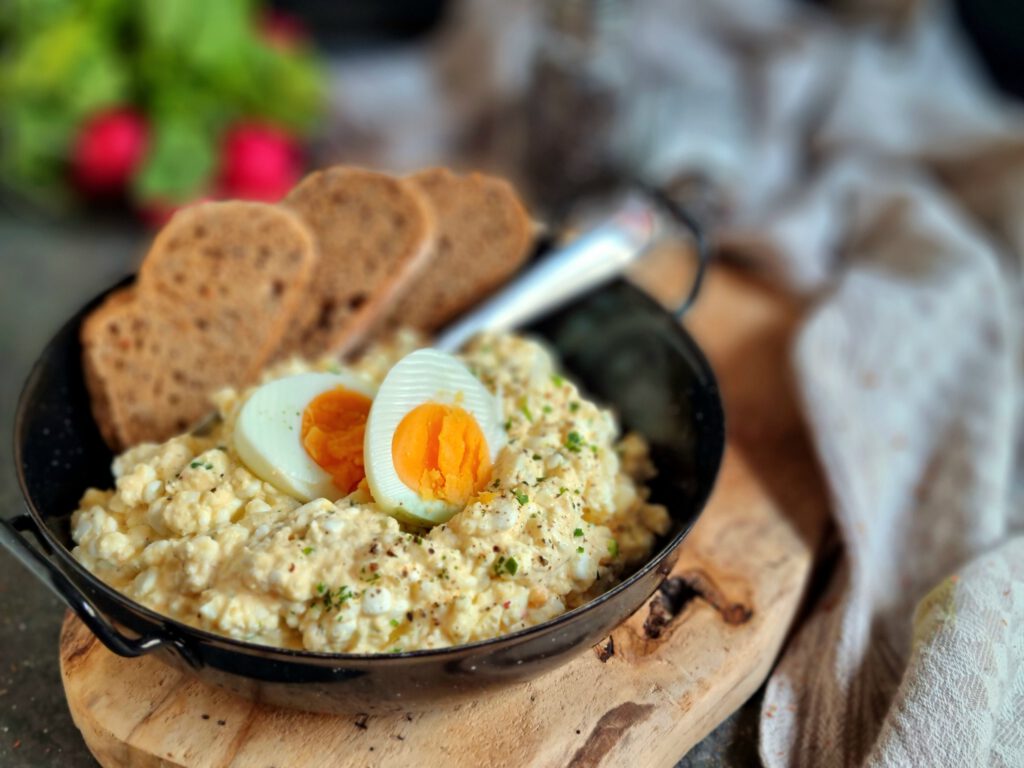 leichter Eiersalat ohne Mayonnaise in einer Sevierpfanne angerichtet
