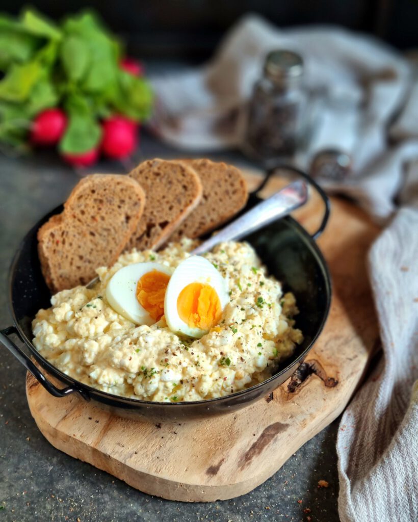 Ein Teller mit cremigen Eiersalat ohne Mayonnaise, zubereitet mit Hüttenkäse und Eiern