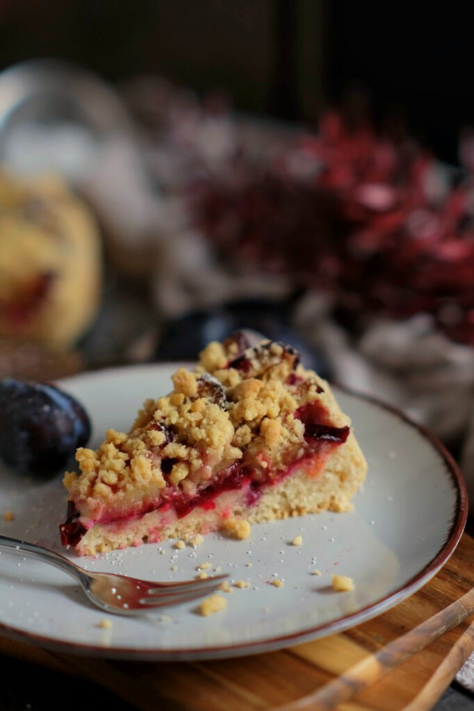 Ein Stück hausgemachter Zwetschgenkuchen mit Streuseln, bereit für den Nachmittagskaffee
